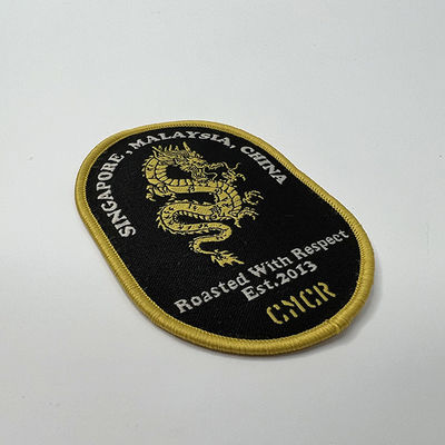 Kundengebundene Grenze Schmelzklebende Dragon Embroidery Patches Shrink Proofs Merrow